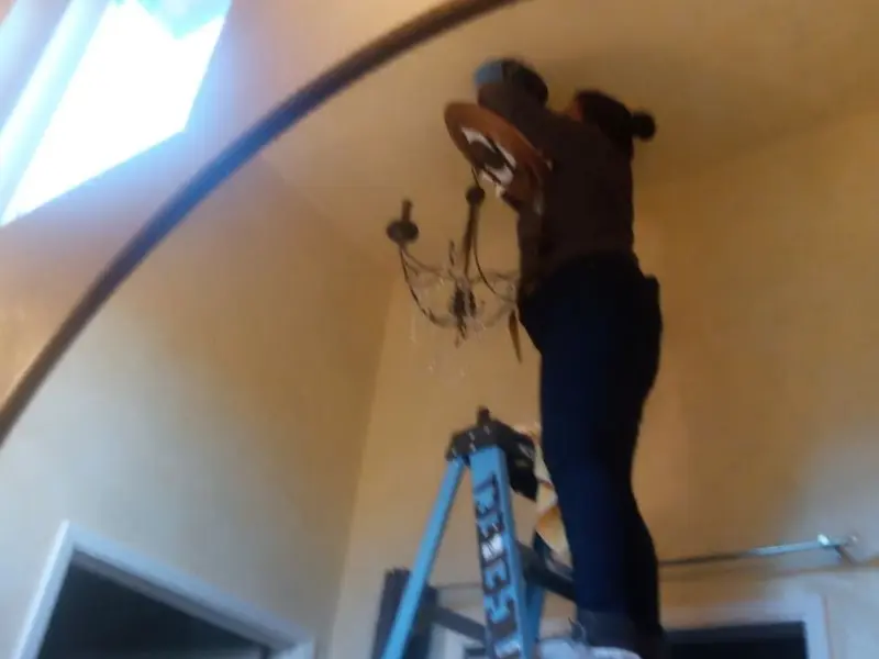 Electrician installing a chandelier in a McCalla residence